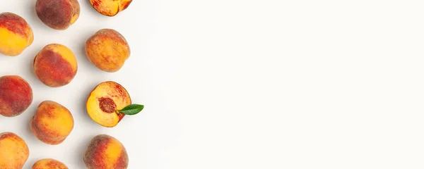 Плоская композиция с персиками. Спелые сочные персики с зелеными листьями на белом фоне. Плоская лежала, вид сверху, копировальное пространство. Творческий персиковый рисунок. Свежие органические продукты. Концепция сбора урожая — стоковое фото