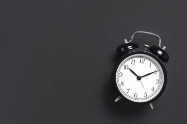 Gri koyu arka plan en iyi görünüm düz siyah retro çalar saat kopya alanı yatıyordu. Minimalist arka plan, zaman, son tarih, çalışmak için zaman, sabah kavramı