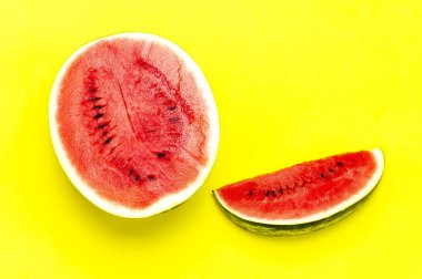 Yarı ve parlak sarı arka planda olgun sulu kırmızı karpuz parçaları. Düz yatıyordu, üst görünüm, kopya alanı. Yaratıcı yaz yemeği konsepti