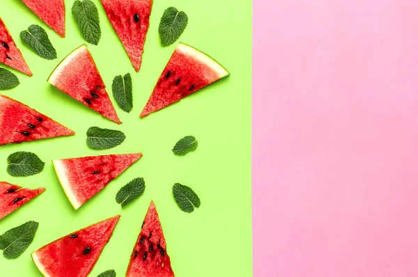 Watermeloen patroon. Sappige plakjes rijpe rode watermeloen en Mint bladeren op veelkleurige roze en groene achtergrond. Platte lay, bovenaanzicht, kopieer ruimte. Creatief zomer voedsel concept — Stockfoto