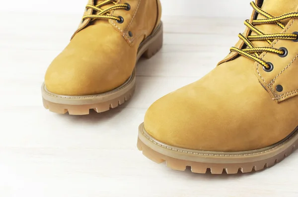 Close-up gele mannen werk laarzen van natuurlijke nubuck leer op houten witte achtergrond. Trendy casual schoeisel jeugd stijl. Concept van reclame herfst winter schoenensale Shop — Stockfoto
