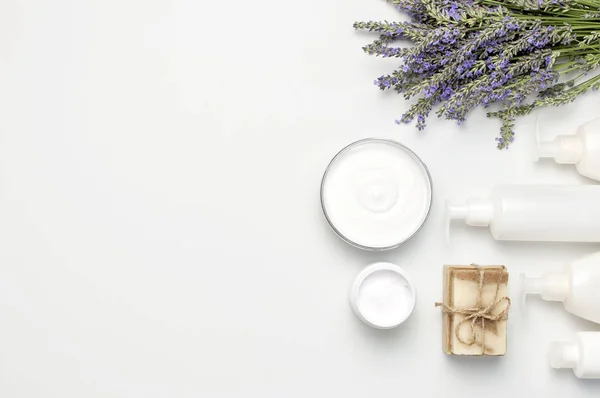 Concept van natuurlijke Spa cosmetica. Open jar van hand-, gezichts-of Lichaamscrème, witte cosmetica flessen, zeep en lavendel op witte achtergrond bovenste weergave Kopieer ruimte. Natuurlijke kruiden huidverzorgingsproducten — Stockfoto