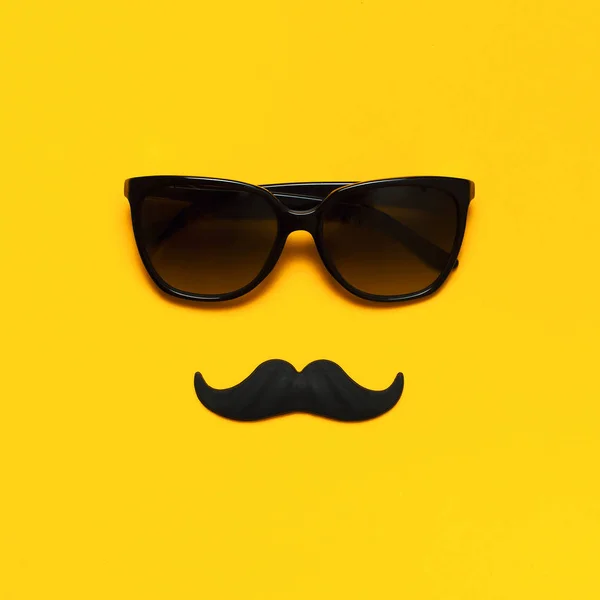 Conceito de decoração de festa criativa. bigode preto, óculos de sol, adereços para cabines de fotos, festas de carnaval no fundo amarelo vista superior plana leigos espaço de cópia. Dia do pai Dia da consciência da saúde dos homens — Fotografia de Stock