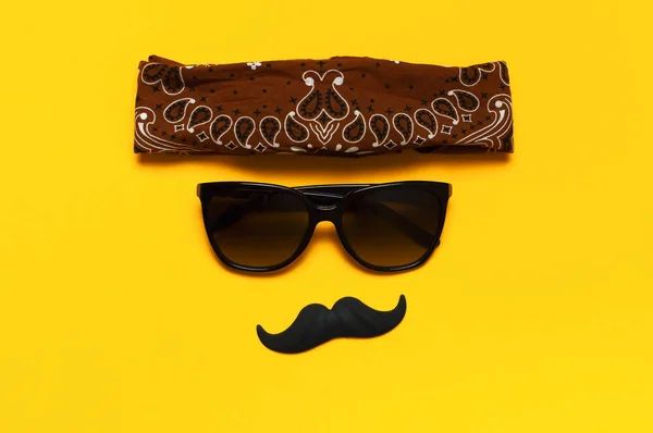 Conceito de decoração de festa criativa. bigode preto, óculos de sol, adereços para cabines de fotos, festas de carnaval no fundo amarelo vista superior plana leigos espaço de cópia. Dia do pai Dia da consciência da saúde dos homens — Fotografia de Stock