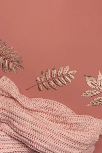 Composition plate de l'automne. Pull ou plaid femme rose laine tricoté, feuilles dorées sèches sur fond brun bordeaux vue du dessus copier l'espace. Concept d'automne. Couleur de la mode, chose d'automne confortable, vêtements — Photo