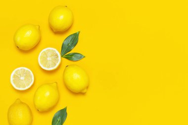 Olgun sulu limon ve parlak sarı zemin üzerine yeşil yaprakları. Limon meyve, narenciye en az kavramı, vitamin C. yaratıcı yaz yiyecek minimalist arka plan. Düz yatıyordu, en iyi görünüm, kopya alanı