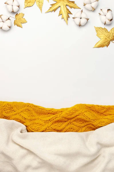 Composition plate de l'automne. Pull ou carreaux tricotés en laine beige clair et jaune orangé, feuilles dorées sèches, fleurs en coton sur fond blanc vue du dessus espace de copie. Automne, concept d'automne — Photo