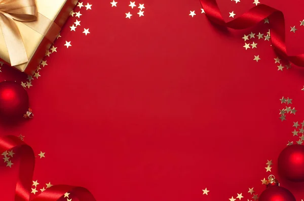 Ano Novo Natal presentes dourados com fita, bolas de Natal, estrelas de confete de ouro no fundo vermelho vista superior. Flat lay Natal feriado 2020 celebração. Caixas de presente cartão de saudação Decorações festivas — Fotografia de Stock