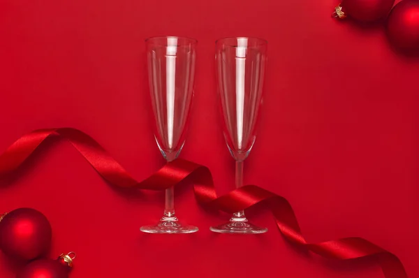 Nowy rok Christmas kieliszek szampana, kule świąteczne, Złote konfetti gwiazdki na czerwonym tle widok z góry z przestrzeni kopiowania. Płaski lay Xmas święto 2020 uroczystości. Kartki okolicznościowe Dekoracje świąteczne — Zdjęcie stockowe