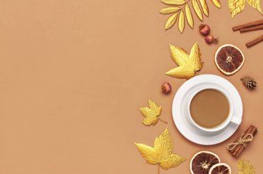 Sonbahar kompozisyonu. Beyaz kahve ya da kakao, altın akçaağaç yaprağı, tarçın, kurutulmuş portakal, kozalak, bej arka planda nar. Düz konum, üst görünüm, kopyalama alanı. Sonbahar, sonbahar konsepti