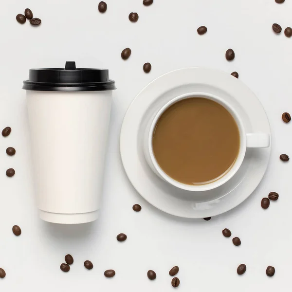 Coffee or tea paper cup, white cup with coffee, coffee beans on light gray background top view flat lay copy space. Take away coffee cup, mockup. Minimal composition, layout for design