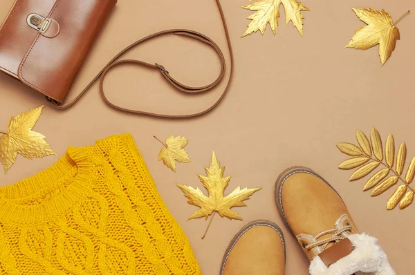 Brunt läder kvinnor väska, orange stickad tröja, varma stövlar, gyllene höstlöv på brun bakgrund uppifrån och ner Flat Lay. Fashionabla kvinnors accessoarer. Höstens modekoncept. Snygga Lady kläder — Stockfoto