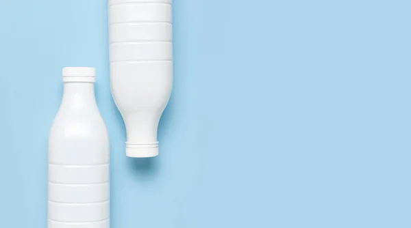 Witte plastic flesjes voor zuivelproducten op blauwe achtergrond bovenaanzicht plat gelegd. Plastic Kefir Yoghurt Milk Bottle. Verpakking template mockup. Indeling voor uw ontwerp — Stockfoto
