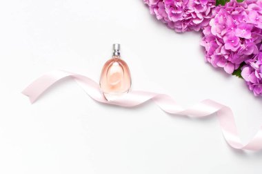 Parfüm şişesi, pembe ortanca çiçekler, hafif arka plan üst görünüm Düz tatil şeritler kopyalama alanı yatıyordu. Parfümeri, kozmetik, kadın aksesuarları, koku koleksiyonu. Hassas Parfüm Şişesi