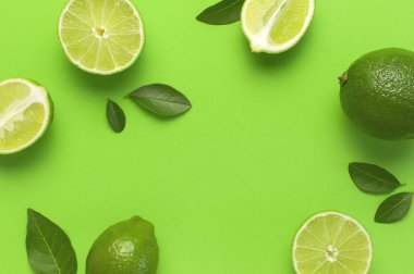 Taze sulu limon ve parlak yeşil arka planda yeşil yapraklar. Üst görünüm düz kopya alanı. Yaratıcı gıda geçmişi, tropikal meyve, C vitamini, narenciye. Bütünüyle kompozisyon ve limon dilimleri