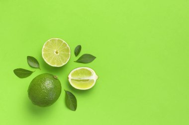 Taze sulu limon ve parlak yeşil arka planda yeşil yapraklar. Üst görünüm düz kopya alanı. Yaratıcı gıda geçmişi, tropikal meyve, C vitamini, narenciye. Bütünüyle kompozisyon ve limon dilimleri