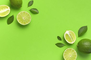 Taze sulu limon ve parlak yeşil arka planda yeşil yapraklar. Üst görünüm düz kopya alanı. Yaratıcı gıda geçmişi, tropikal meyve, C vitamini, narenciye. Bütünüyle kompozisyon ve limon dilimleri