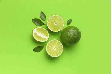 Taze sulu limon ve parlak yeşil arka planda yeşil yapraklar. Üst görünüm düz kopya alanı. Yaratıcı gıda geçmişi, tropikal meyve, C vitamini, narenciye. Bütünüyle kompozisyon ve limon dilimleri