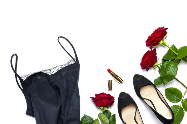 T-shirt femme noire avec dentelle, chaussures classiques, rouge à lèvres et fleurs roses sur fond blanc vue de dessus à plat. Beauté fond de mode. Vêtements sexy, vacances pour femmes — Photo