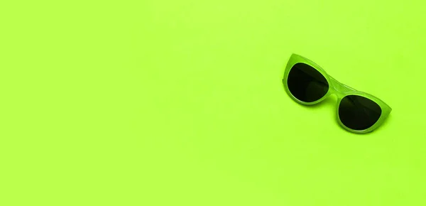 Stylowe zielone okulary przeciwsłoneczne z czarnymi okularami na jasnozielonym tle widok płaski leżał przestrzeń kopii. Okulary modowe, akcesoria letnie, hipster, wakacje minimalny styl młodzieżowy. Tło letnie — Zdjęcie stockowe