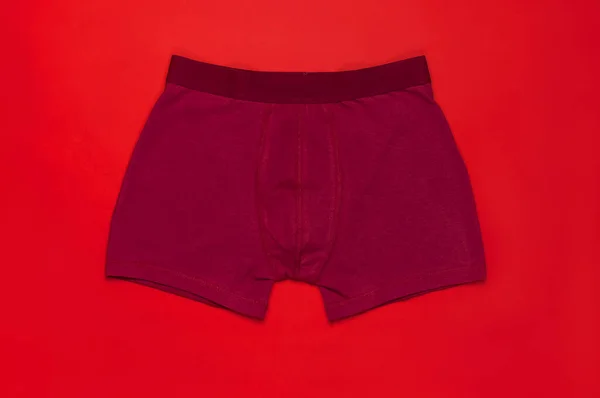 Biancheria intima da uomo, rosso bordeaux mutande su sfondo rosso piatto lay top view copy space. Fashion blog, biancheria intima naturale, pubblicità, concetto di shopping. Pantaloni boxer — Foto Stock