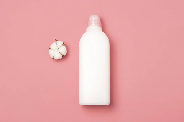 Концепція екологічного очищення. Біла пластикова упаковка прального порошку, рідкого порошку, кондиціонера для прання та бавовняних квітів на рожевому фоні. Плоский простір копіювання зверху. Біоорганічний продукт — стокове фото