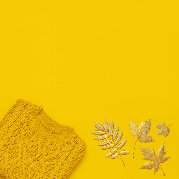 秋平铺组成。橙色黄色针织羊毛女毛衣和金色叶子在黄色背景顶视图。时尚女士的秋季配饰。舒适的针织跳线时尚女士服装 — 图库照片