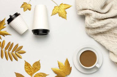 Kahve ya da kağıt bardak, kahve ile beyaz bardak, altın sonbahar yaprakları, açık arkaplan manzaralı ekose örgü düz. Kahve fincanını çıkar, manken. Sonbahar konsepti. Sonbahar arkaplanı Sıcak kahvaltı