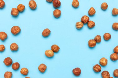 Yaratıcı gıda düzeni. Mavi arkaplandaki fındıklar üst görünüm kopyalama alanı. Yiyecek kavramı, sağlıklı beslenme, fındık, sağlıklı yağ. Fındık ezmesi. Ceviz deseni. Organik sağlıklı vejetaryen atıştırması