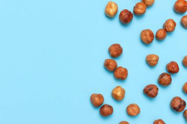 Yaratıcı gıda düzeni. Mavi arkaplandaki fındıklar üst görünüm kopyalama alanı. Yiyecek kavramı, sağlıklı beslenme, fındık, sağlıklı yağ. Fındık ezmesi. Ceviz deseni. Organik sağlıklı vejetaryen atıştırması