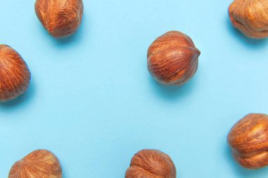 Yaratıcı gıda düzeni. Mavi arkaplandaki fındıklar üst görünüm kopyalama alanı. Yiyecek kavramı, sağlıklı beslenme, fındık, sağlıklı yağ. Fındık ezmesi. Ceviz deseni. Organik sağlıklı vegan atıştırmalık makro shot.