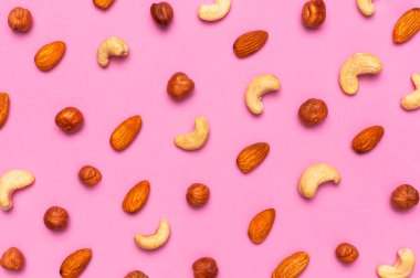 Yaratıcı gıda düzeni. Fındıklı kaju bademi pembe arka plan manzaralı fotokopi alanı. Sağlıklı beslenme kavramı. Sağlıklı beslenme kavramı. Fındık ezmesi. Ceviz deseni. Organik sağlıklı vejetaryen atıştırması