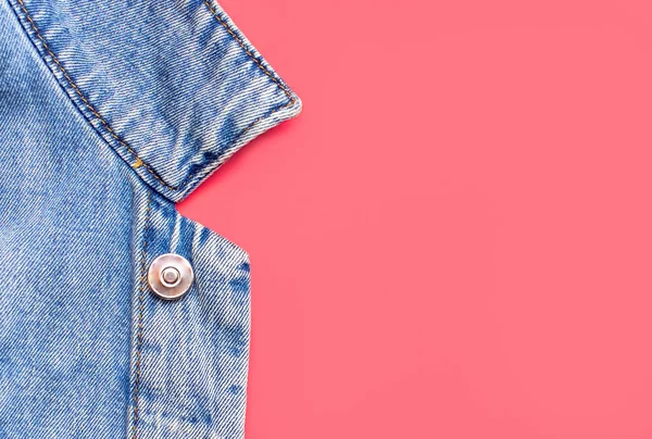 Close-up Niebieska kurtka dżinsowa na różowym tle widok z góry płaski leżał przestrzeń kopii. Jeansy, modna kurtka, damska lub męska modna odzież, tło mody. Tekstura jeansowa — Zdjęcie stockowe