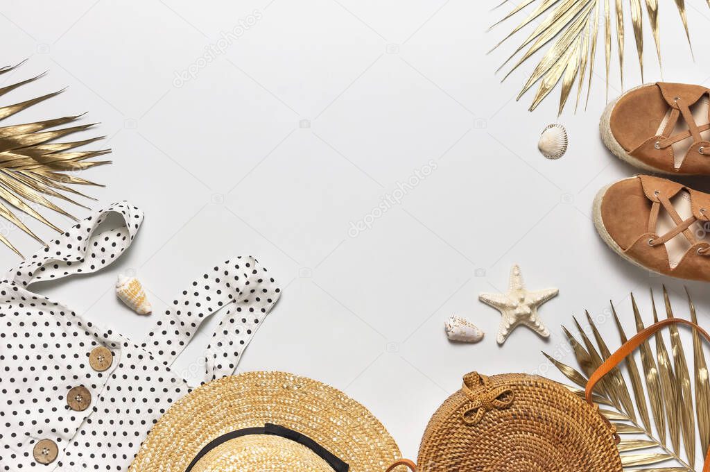 Summer women's white dress in black peas rattan woven bag brown sandals straw hat golden palm leaf shells starfish on light background. Flat lay top view. Women's beach fashion, travel vacation.