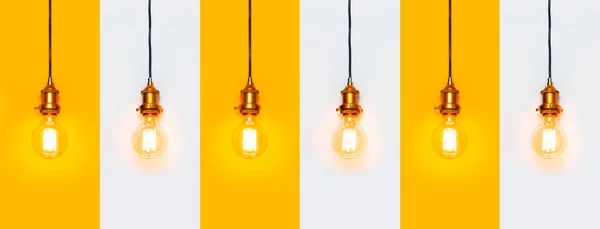 Creative idea concept, designer lamp, modern interior item. Vintage fashionable edison lamp on the same line on gray and yellow background. Top view flat lay. Lighting, electricity, pattern with lamp bulb.