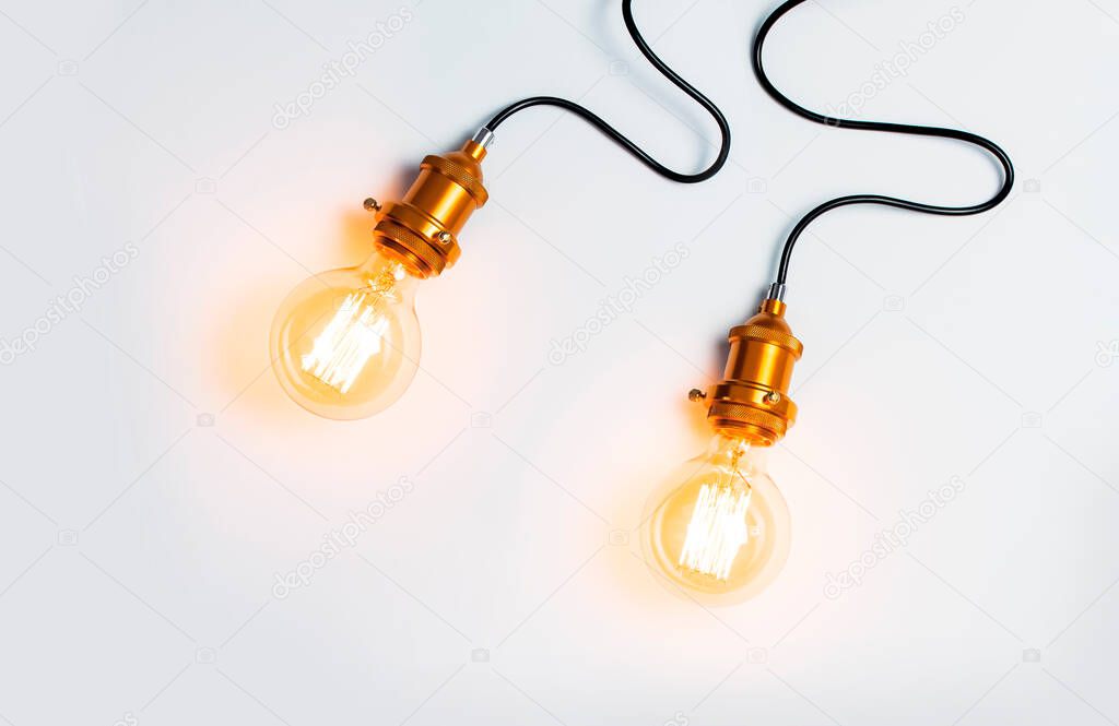 Creative idea concept, designer lamp, modern interior item. Vintage fashionable edison lamp on light gray background. Top view flat lay copy space. Lighting, electricity, background with lamp.