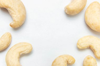 Yaratıcı gıda düzeni. Beyaz arkaplandaki kaju rengi üst görünüm kopyalama alanı. Yiyecek kavramı, sağlıklı beslenme, fındık, sağlıklı yağ. Düz yatıyordu. Kaju deseni. Organik sağlıklı vejetaryen atıştırması.