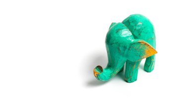 Beyaz arka planda yaldızlı yeşil bir filin heykeli. Bir filin dekoratif figürü, elle oyulmuş ahşap bir fil modeli. Heykel, oyuncak, Asya 'dan hatıra..