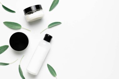 Kozmetik SPA marka modeli. Doğal Güzellik Organik Ürün Konsepti. Krem ve losyonlu kozmetik kaplar, beyaz arka planda bitkisel adaçayı yaprakları düz bir görünüm sergiliyordu. Damgalamak için boş etiket.