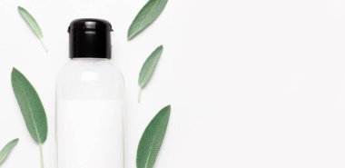 Kozmetik SPA marka modeli. Doğal Güzellik Organik Ürün Konsepti. Krem ve losyonlu kozmetik kaplar, beyaz arka planda bitkisel adaçayı yaprakları düz bir görünüm sergiliyordu. Damgalamak için boş etiket.