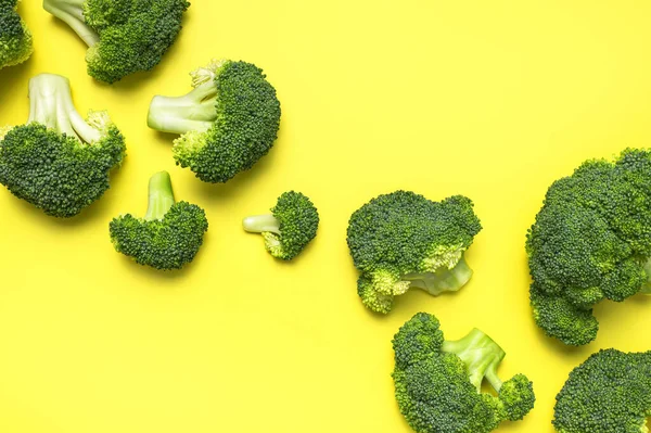 Creative food concept. Fresh raw green broccoli on yellow background. Healthy vegetables, diet vegan organic food, vitamins. Flat lay top view copy space. Broccoli cabbage abstract pattern.