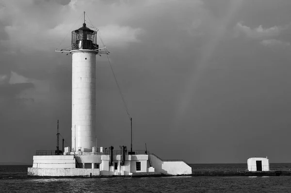 lighthouse in the port of Odessa. Black Sea coast of Ukraine. Black and white landscape with a rainbow.