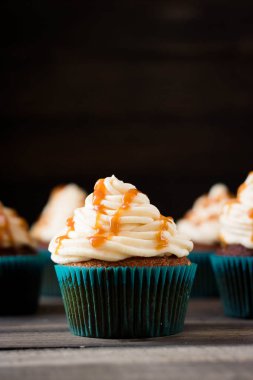 Karanlık bir arka plan üzerinde krem karamel ile cupcakes