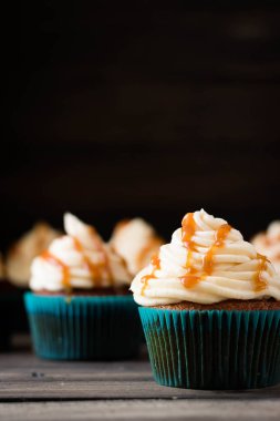 Karanlık bir arka plan üzerinde krem karamel ile cupcakes