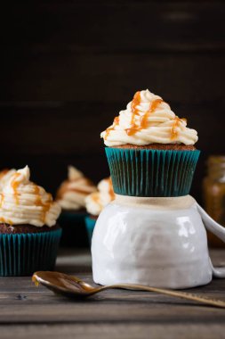 Karanlık bir arka plan üzerinde krem karamel ile cupcakes