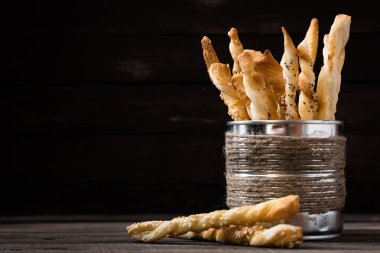 Haşhaş tohumu ve susam bir koyu arka plan üzerinde tinsel rustik kavanozda ekmek sopa