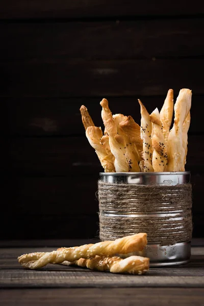 Bread sticks with poppy seeds and sesame in a tinsel rustic jar on a dark background