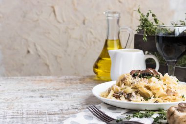 Mantarlı makarna ve krem peynir soslu kızarmış tavuk. Hafif ahşap arka planda.