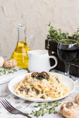 Mantarlı makarna ve krem peynir soslu kızarmış tavuk. Hafif ahşap arka planda.