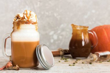 Baharat ve krem şanti bir kap ile baharatlı Sütlü Balkabağı tuzlu karamel ile dekore edilmiş ve kabak çekirdeği ezilmiş